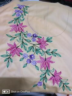 an embroidered cloth with flowers and leaves is being stitched onto the back of a chair