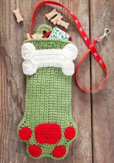 a crocheted bag with a dog bone and bones on it, next to a red leash