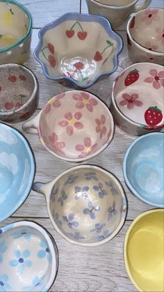 many bowls are sitting on the table with strawberries painted on them and one bowl is empty