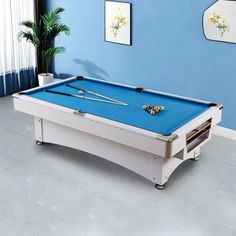 a pool table in the middle of a living room with blue walls and white furniture