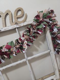 an old window is decorated with ribbons and the word home spelled out in wood letters