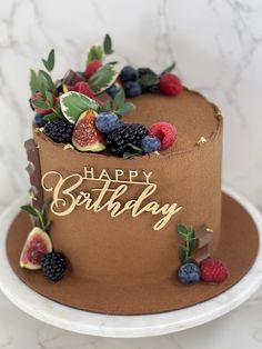 a chocolate birthday cake with fresh fruit on top