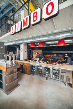 the inside of a restaurant with workers preparing food and drinks on counter tops in front of large sign that reads limbbo