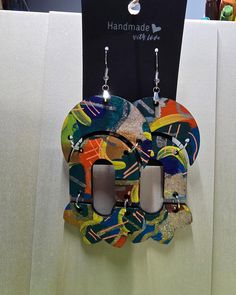 a pair of earrings hanging from the side of a wall