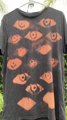 a black shirt with orange eyes on it