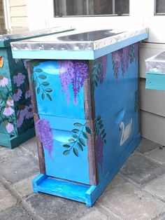 a blue box painted with purple flowers on it