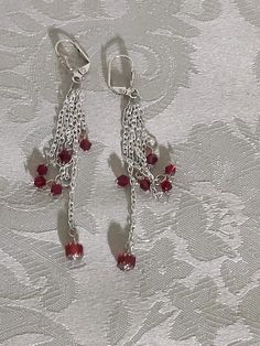 Silver dangle earrings.  Red glass bicones hang on 6 different sized chains. The longest chain is 2.5" and the shortest 1". The silver leverbacks are allergen free. These earrings are classic evening wear and you will feel very elegant wearing them. They will arrive wrapped in tissue in an organza bag and mailed in a bubble envelope. Red Sterling Silver Dangle Crystal Earrings, Red Nickel-free Chandelier Earrings As Gift, Elegant Red Jewelry With Dangling Charms, Red Nickel-free Chandelier Drop Earrings, Red Nickel Free Drop Chandelier Earrings, Red Hypoallergenic Dangle Earrings, Hypoallergenic Red Dangle Earrings, Red Dangle Earrings With Lever Back Ear Wires, Red Dangle Earrings