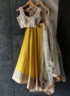 This yellow butti georgette lehenga with heavy gota and zari work border detailing is paired an ivory raw silk blouse in zardozi and pearl work embroidery.  The outfit is completed with an ivory sequin work net dupatta with scallop edging. Yellow Georgette Anarkali Set With Zari Work, Elegant Yellow Lehenga With Resham Embroidery, Elegant Yellow Lehenga In Georgette, Elegant Designer Yellow Lehenga, Yellow Chinon Traditional Wear For Reception, Yellow Chinon Dupatta For Reception, Yellow Zari Work Anarkali Set For Reception, Yellow Anarkali Choli In Chinon, Elegant Yellow Georgette Lehenga