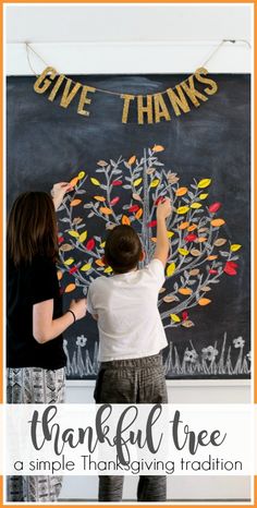 two children are writing on a chalkboard with the words give thanks and thank tree