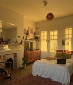 a bed sitting in a bedroom next to a fire place under a window near a fireplace