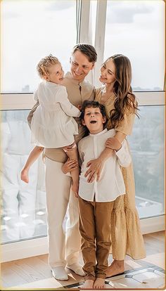 a family posing for a photo in front of a window