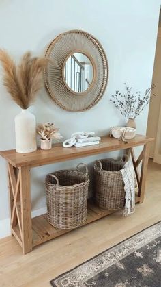 a wooden table topped with baskets next to a mirror