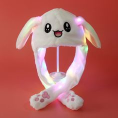 a light up bunny hat on top of a pink surface with white paws and feet