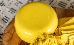 a yellow object sitting on top of a wooden cutting board next to other food items