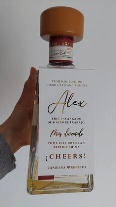 a bottle of alcohol that is being held up in front of a person's hand