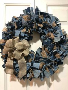 a wreath made out of old jeans and burlocks hanging on the front door