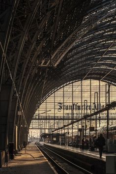 an empty train station with people standing on the platform