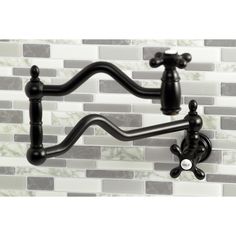 a black sink faucet in front of a white tile backsplash and wall