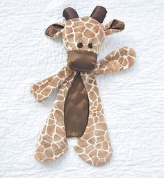 a stuffed giraffe laying on top of a bed