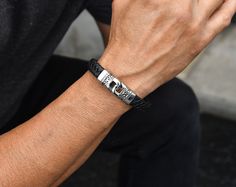 "~Quality, woven black leather bracelet with stainless steel details and magnetic clasp. ~Standard/medium men size - 8.25\". ~Metal components are stainless steel: Water, heat & Sweat resistant. No discolouration or tarnishing (no green skin). Hypoallergenic. Your item will arrive in a drawstring pouch - Ready for Gift Giving! *The beaded set of cross bracelets shown on the model is available separately here: https://www.etsy.com/ca/listing/1298218947/men-bracelet-set-black-lava-beads?click_key=b1a2346407686f4a89acc3070011a68597ec1036%3A1298218947&click_sum=e1d3c0a6&ref=shop_home_active_14&pro=1" Black Leather Magnetic Bracelet As A Gift, Black Magnetic Leather Bracelet As Gift, Modern Black Braided Bracelets For Gift, Modern Black Braided Bracelets As Gift, Modern Black Braided Bracelet Gift, Modern Black Braided Bracelet As Gift, Black Luxury Braided Bracelets As Gift, Luxury Black Braided Bracelet As Gift, Magnetic Black Leather Bracelet Gift