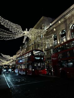 the double decker bus is driving down the street with christmas lights strung all over it