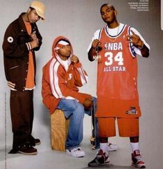 three young men standing next to each other in front of a basketball player wearing an orange jersey