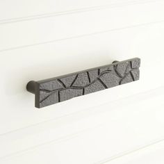 a close up of a door handle on a white wall with black and gray designs