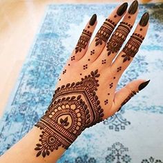 a woman's hand with henna tattoos on it