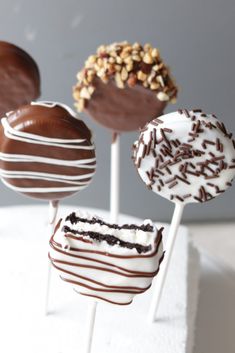 four chocolate covered cake pops sitting on top of each other