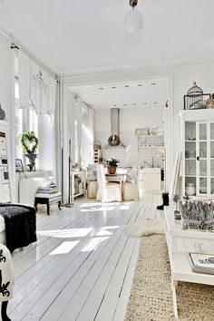 a white living room filled with furniture and decor