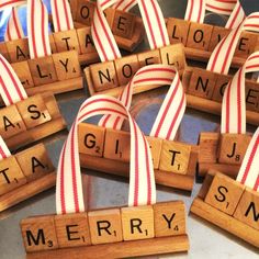 wooden scrabbles with red and white ribbons are arranged in the shape of letters spelling merry