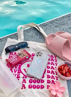 a tote bag sitting next to a swimming pool filled with fruit and other items