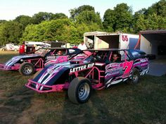 three pink race cars parked next to each other