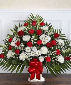 a red and white basket with flowers in it