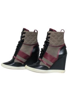 a pair of black and grey wedged boots with red accents on the side,