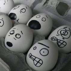 eggs with faces drawn on them in an egg carton