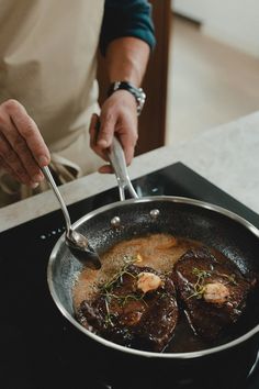 a person is cooking some food in a pan on the stove top with a spoon