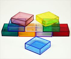 several different colored boxes sitting on top of each other in front of a white background