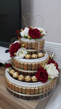 three tiered cake decorated with chocolates and roses