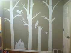 a room with white trees painted on the wall