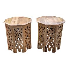 a pair of wooden tables with intricate carvings on the top and bottom, sitting side by side