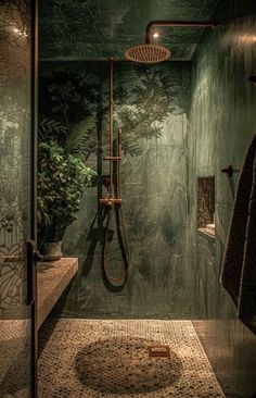 a bathroom with green walls and tile flooring, shower head is on the wall