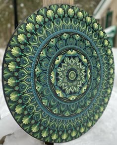 a green and blue plate sitting on top of snow covered ground