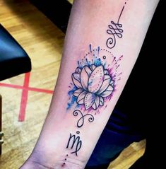 a woman's arm with a watercolor tattoo design on the left side of her wrist