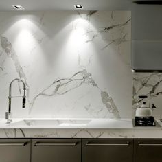 a kitchen with marble counter tops and stainless steel cabinets, along with recessed lighting