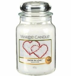 yankee candle with two hearts on it and the words snow in love written across the jar