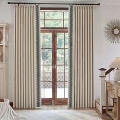 a living room with white walls and curtains