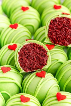 green macaroons with red heart decorations on them