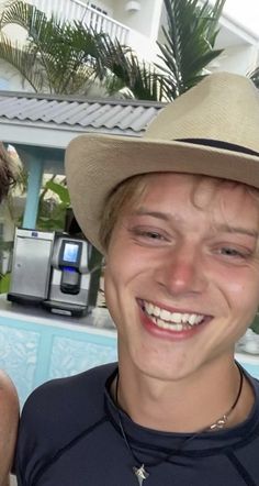 two men are smiling for the camera in front of a swimming pool