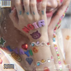 a woman with her hands on her face covered in colorful beads and letters that spell out the word love